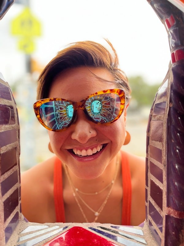 Heather, the teacher behind SLO Yoga California, smiling in colorful sunglasses